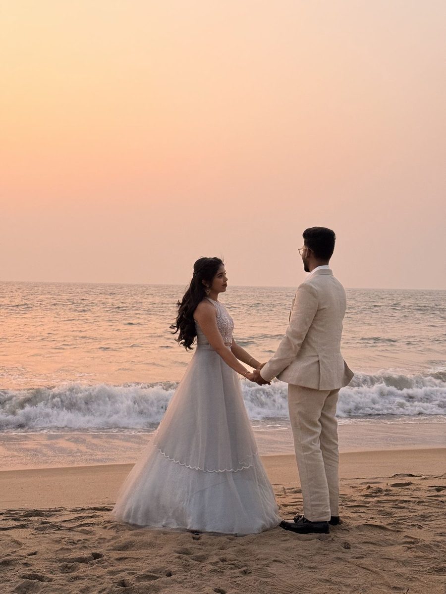 Keerthy and Rosheel holding hands on the beach at sunset